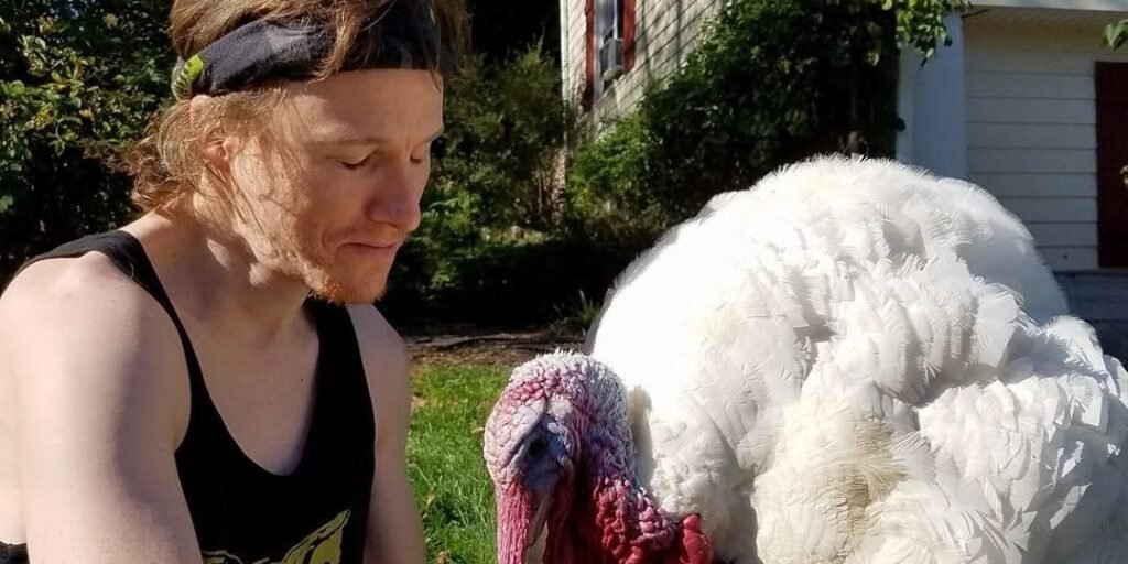 A man beside a rescued turkey